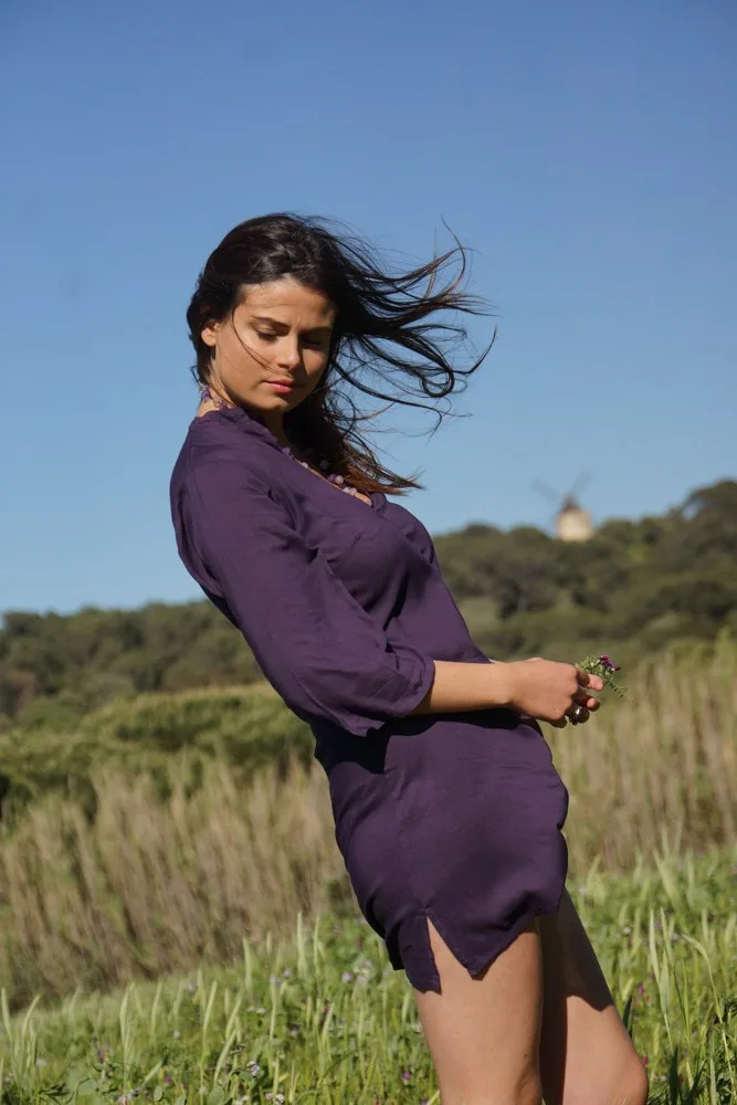 Femme en tunique pourpre, cheveux au vent, dans l'herbe haute avec un moulin sur la colline à Porquerolles.