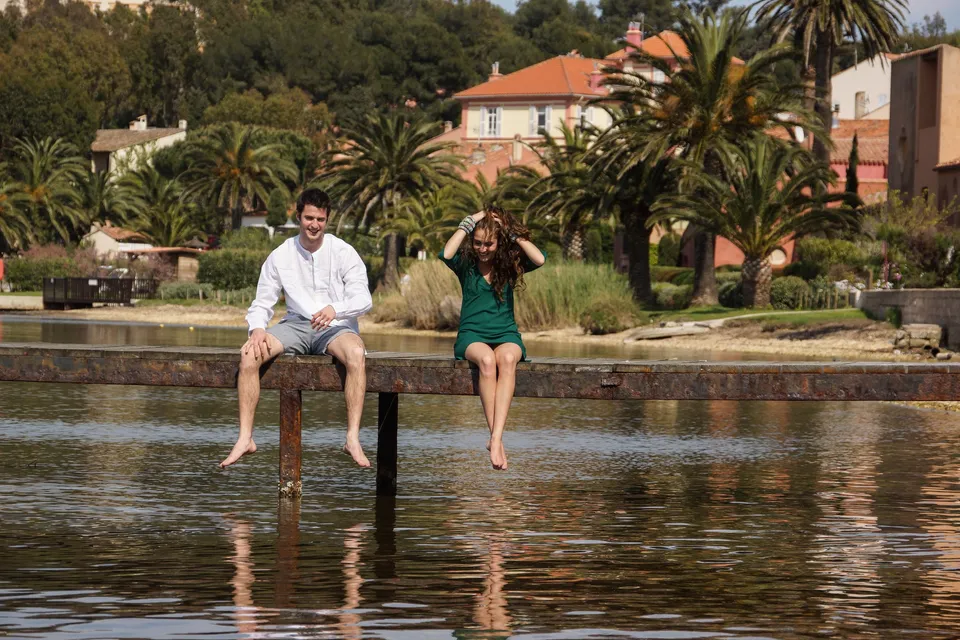 Femme en robe verte et homme en chemise blanche sur un ponton à Porquerolles.