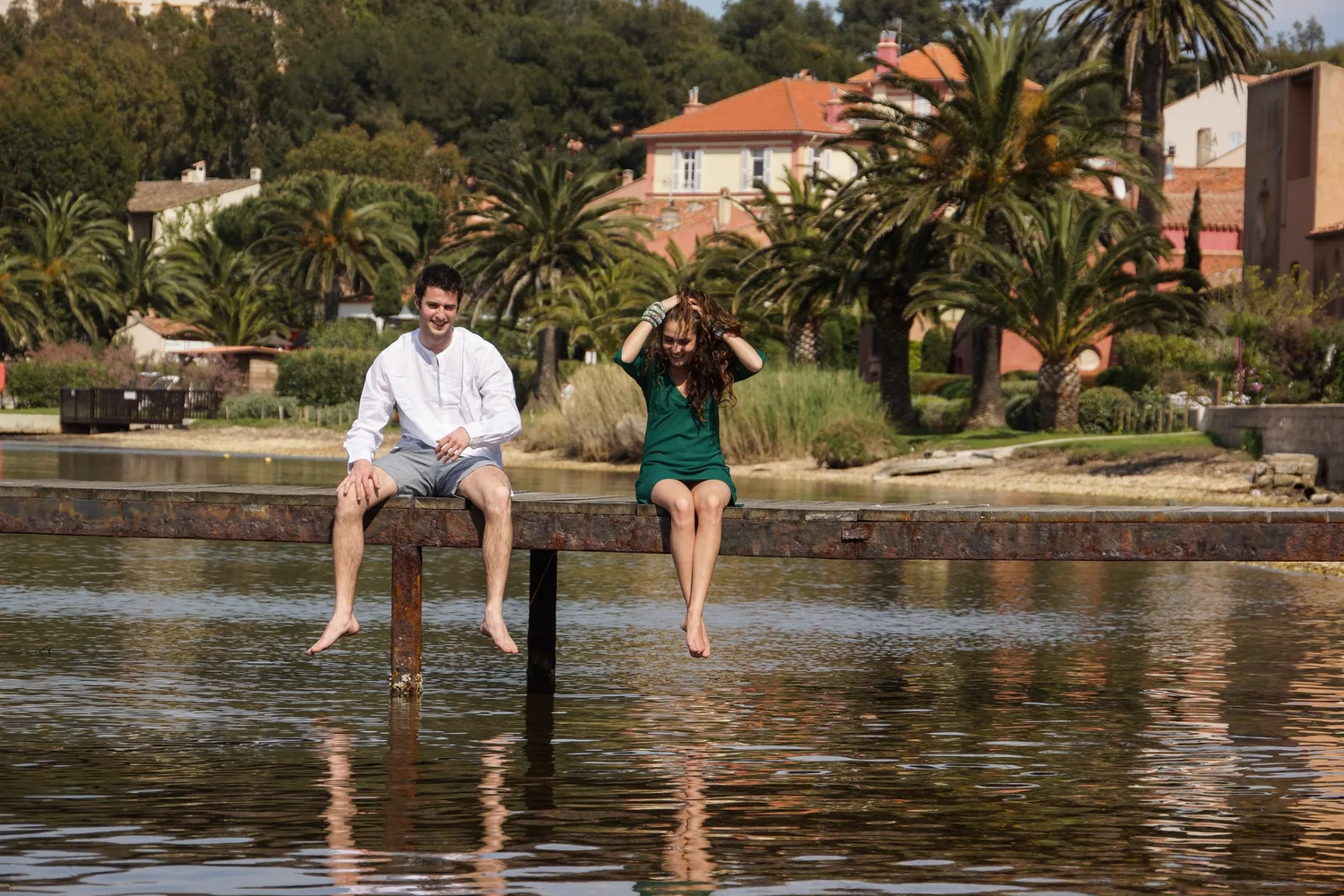 Femme en robe verte et homme en chemise blanche sur un ponton à Porquerolles.