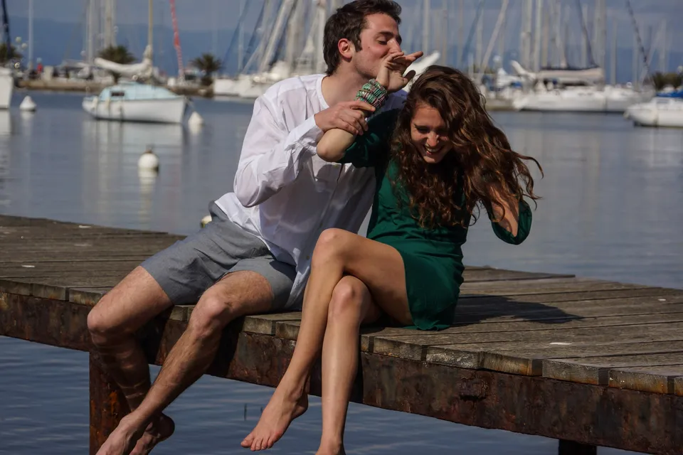 Femme en robe verte et homme en chemise blanche sur un ponton à Porquerolles.