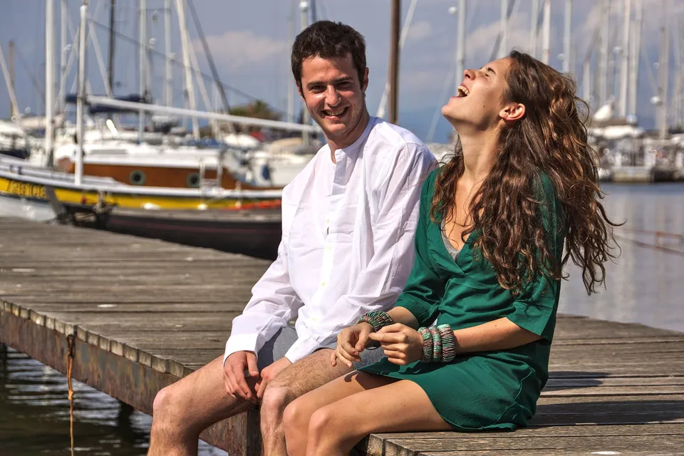 Femme en robe verte et homme en chemise blanche sur un ponton à Porquerolles.
