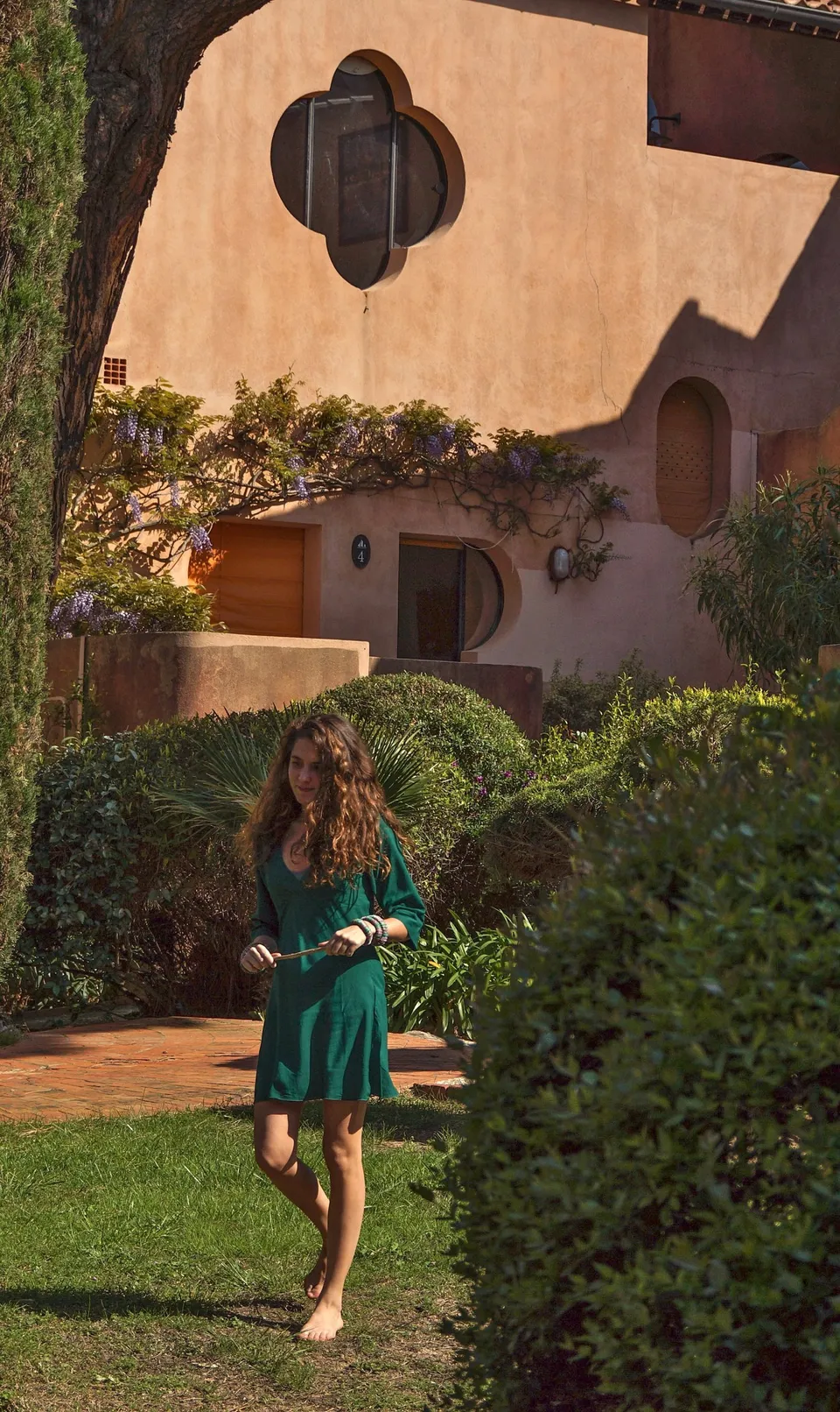 Femme en robe verte dans un jardin méditerranéen à Porquerolles.