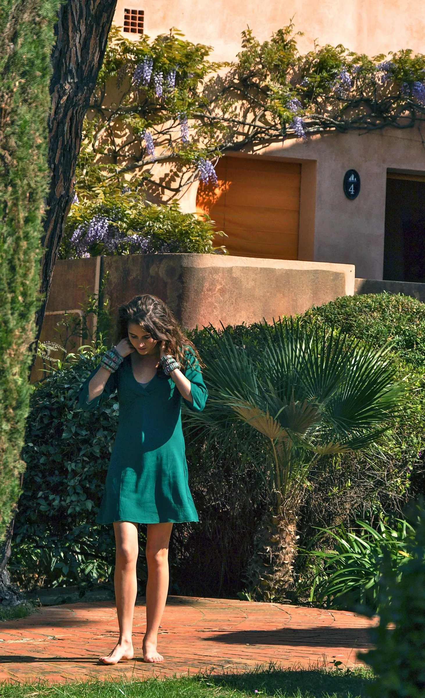 Femme en robe verte dans un jardin méditerranéen à Porquerolles.
