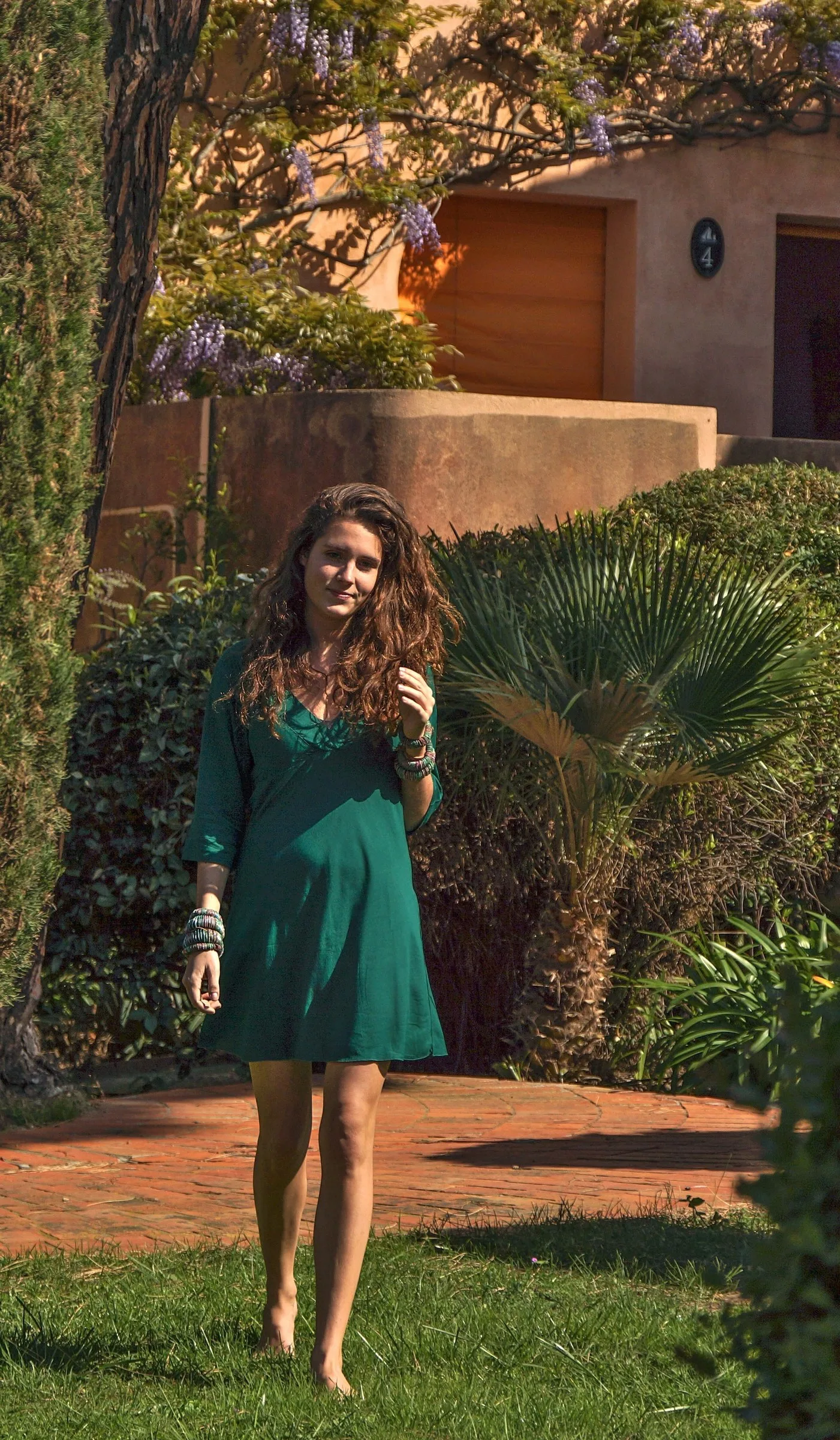 Femme en robe verte dans un jardin méditerranéen à Porquerolles.