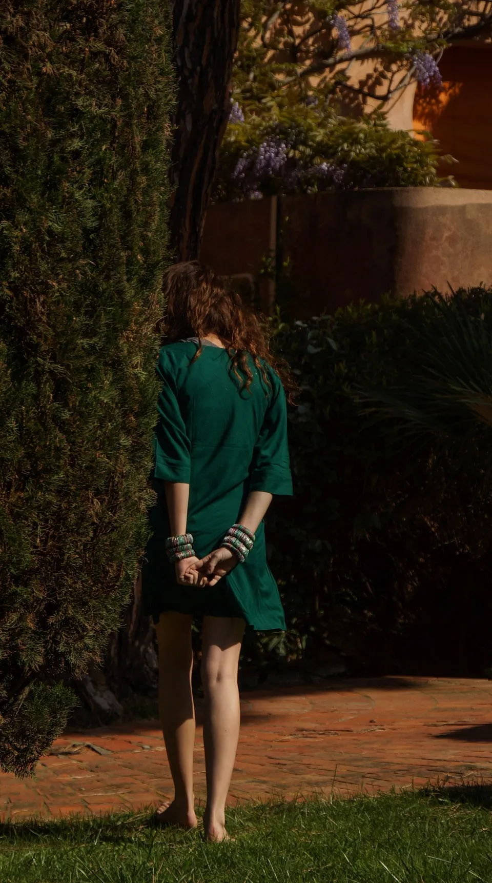 Femme en robe verte dans un jardin méditerranéen à Porquerolles.