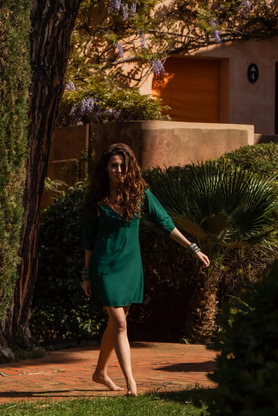 Femme en robe verte dans un jardin méditerranéen à Porquerolles.