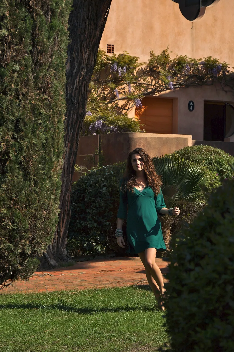 Femme en robe verte dans un jardin méditerranéen à Porquerolles.