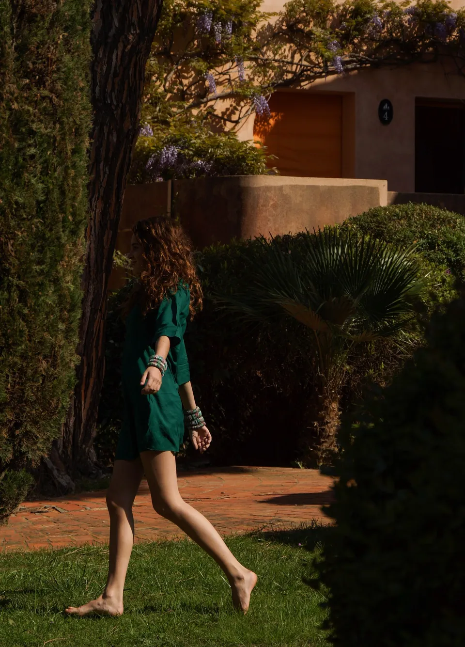 Femme en robe verte dans un jardin méditerranéen à Porquerolles.