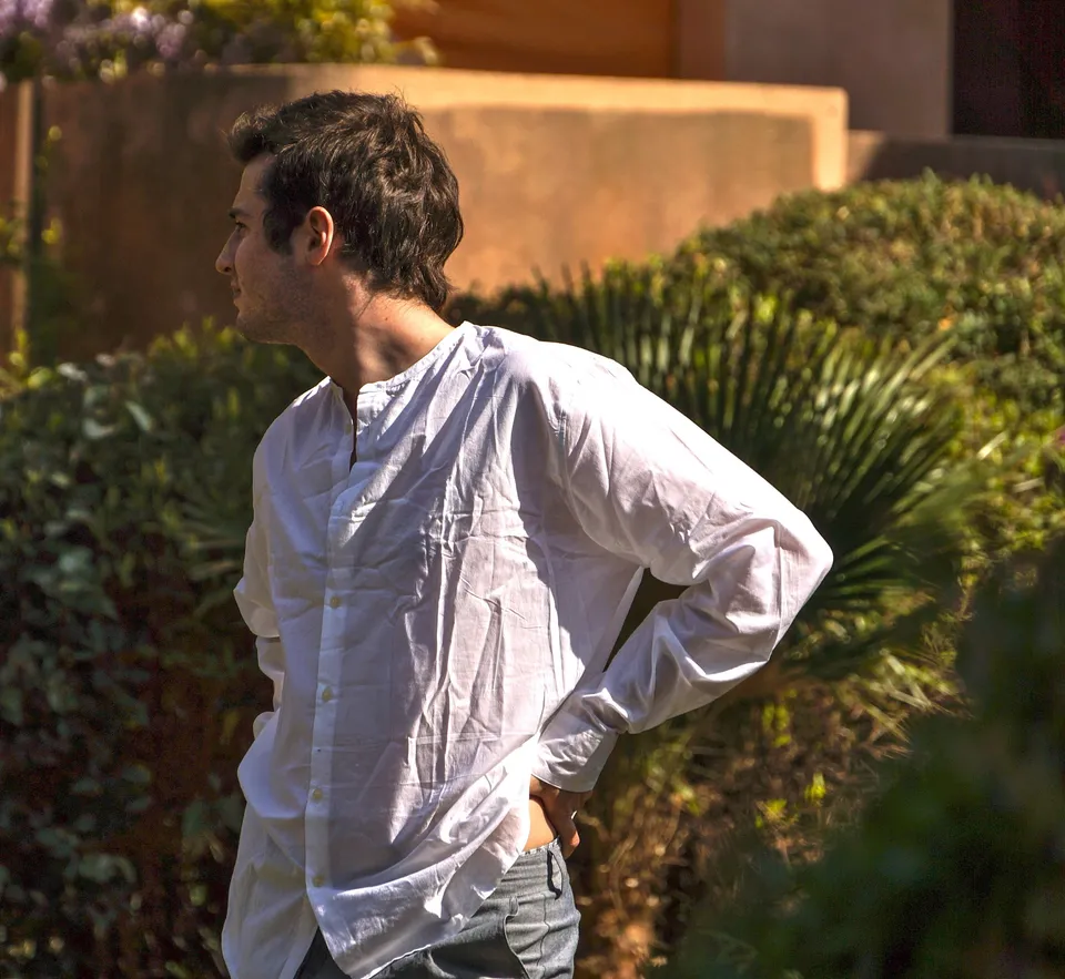 Homme en chemise blanche dans un jardin méditerranéen à Porquerolles.