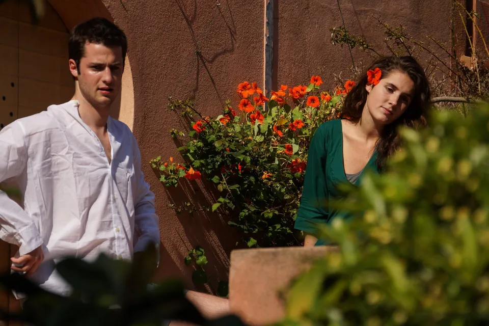 Femme en tenue grise avec un homme en chemise blanche dans un jardin à Porquerolles.