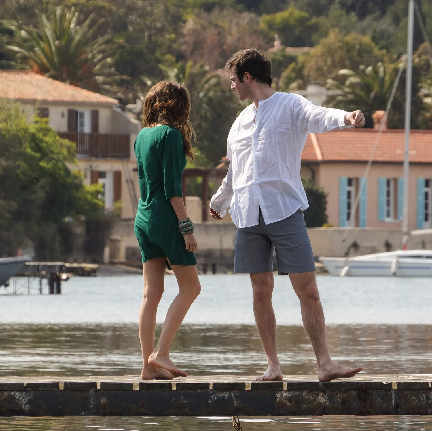 Femme en robe verte et homme en chemise blanche près du port de Porquerolles.
