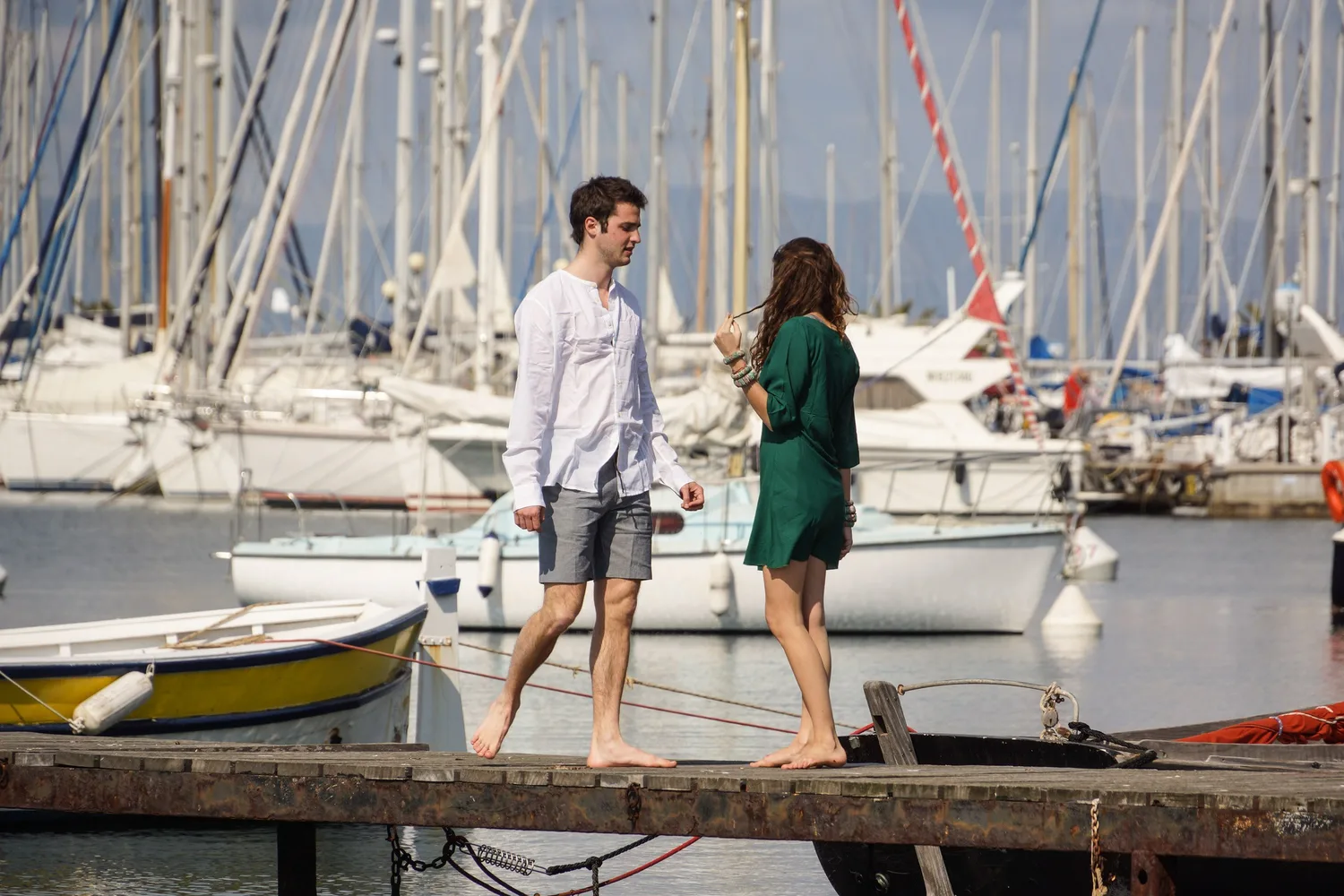Femme en robe verte et homme en chemise blanche près du port de Porquerolles.