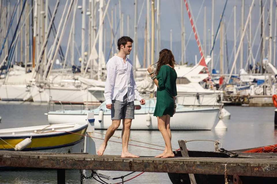 Femme en robe verte et homme en chemise blanche près du port de Porquerolles.