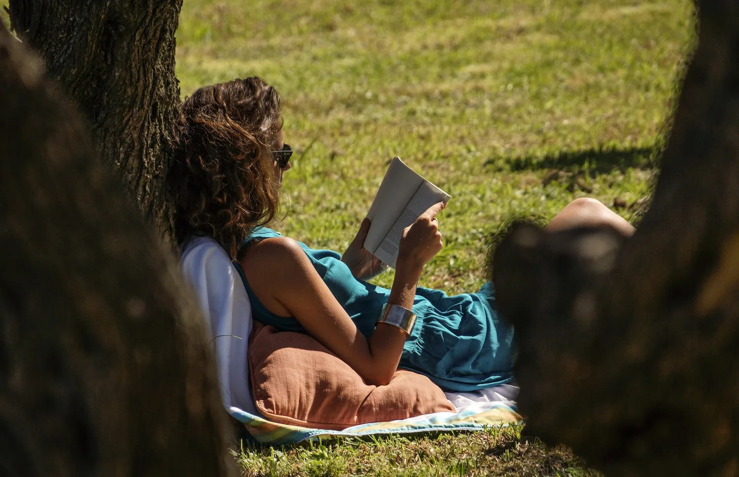 Femme en tenue bleue lisant dans l’herbe à Porquerolles.