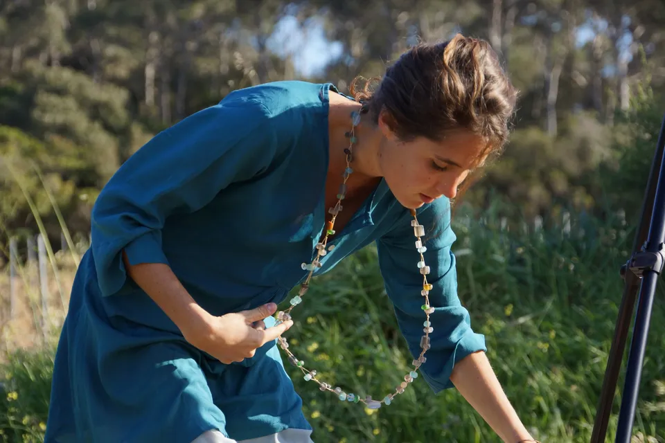 Femme en tunique bleue et chapeau de paille dans le maquis de Porquerolles.